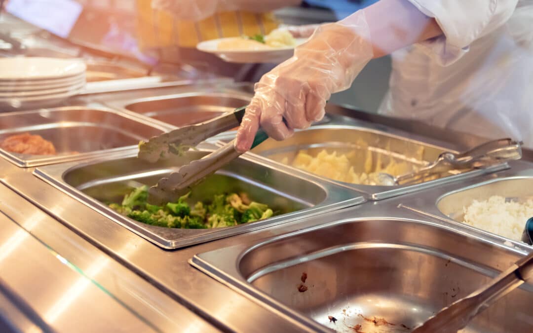 Chef standing behind full lunch service station with assortment