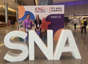 Tibersoft's Suzanne Cwik and Cameron Irvine smiling for a photo behind the official sign for the SNA Annual National Conference 2025.