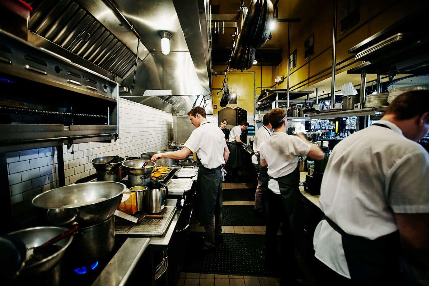 Kitchen staff cooking in a busy commercial restaurant kitchen